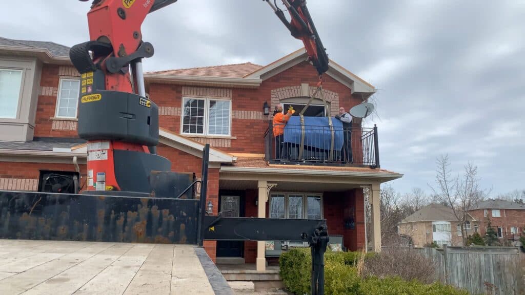 Craning an upright piano off a house balcony