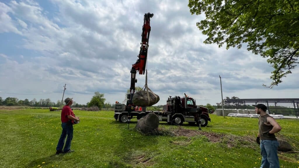 Crane lifting large landscape rocks weighing 1-2 tonnes