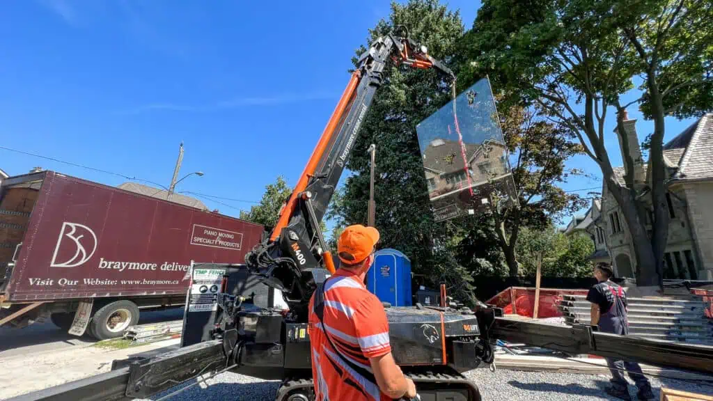 Spider crane lifting a glass window on a construction site