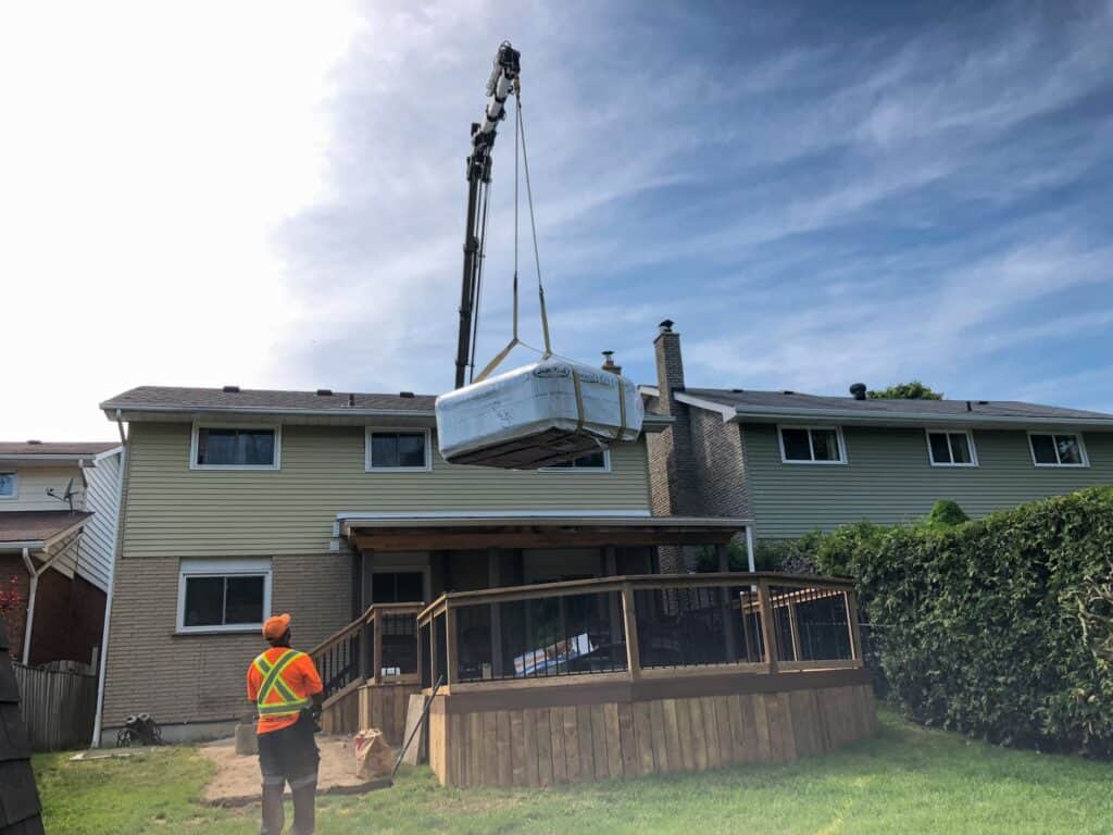 Craning a hot tub over a house and onto a backyard deck