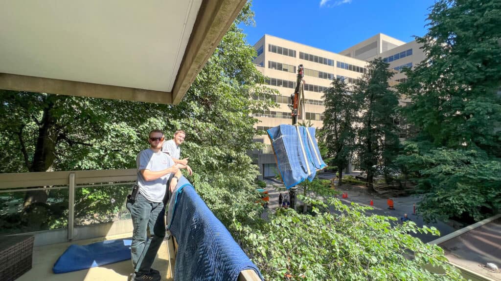 Using a spider crane to lift a large china cabinet on to an apartment building balcony because it was too large to fit in the elevator.