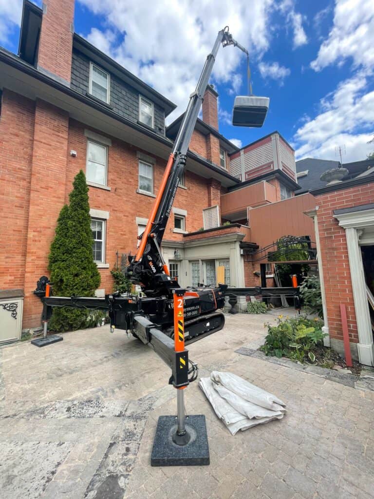 A spider knuckle crane lift a hot tub onto a 3rd floor balcony in Toronto