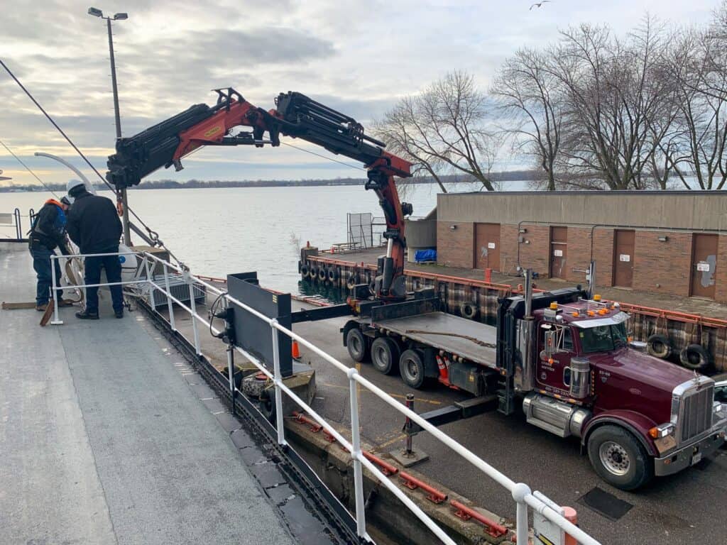 Lifting items with a knuckle crane safely onto a boat.