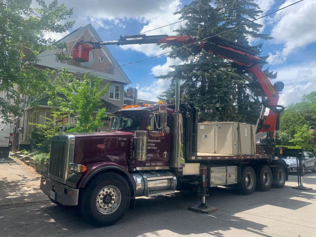 Using a crane man basket to lift person up to work on the side of a house