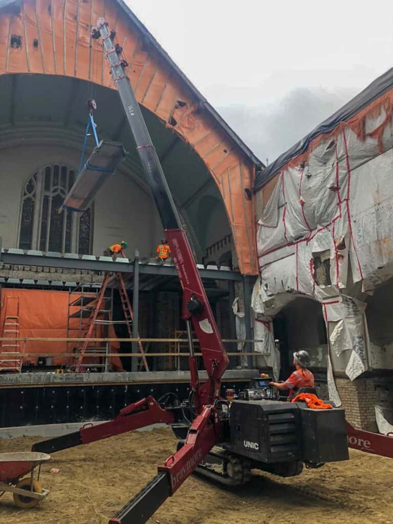 Spider crane hoisting beams to second floor